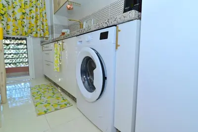 a white washing machine in a white laundry room at Stylish appartment,5min to airport fiber&netflix in Marrakech