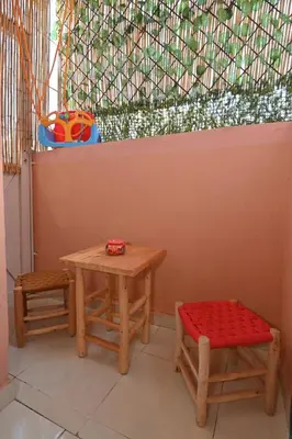 a table and two stools in front of a window at Stylish appartment,5min to airport fiber&netflix in Marrakech