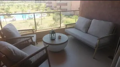 a living room with a couch and a table at Appartement 2 chambres a PRESTIGIA piscine in Marrakech