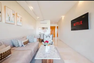 a living room with a couch and a table at Appartement 2 chambres a PRESTIGIA piscine in Marrakech