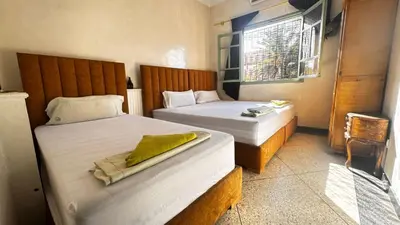 a bedroom with two beds and a window at Les appartements de la Koutoubia in Marrakech