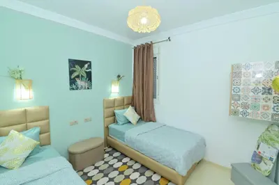 a bedroom with two beds and a couch at Stylish apartment, 5 min to airport fiber&Netflix in Marrakech
