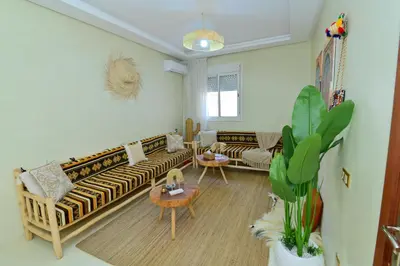 a living room with a couch and a table at Stylish apartment, 5 min to airport fiber&Netflix in Marrakech