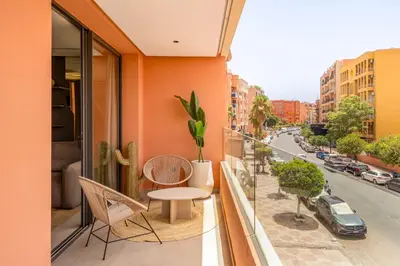 a balcony with a table and chairs and a street at Guéliz Centre Haut Standing in Marrakech