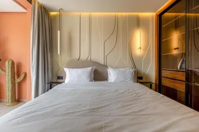 a bedroom with a large bed with white sheets at Guéliz Centre Haut Standing in Marrakech