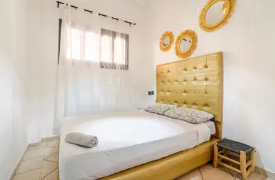 a bedroom with a large bed and a mirror at Stay here in Marrakech