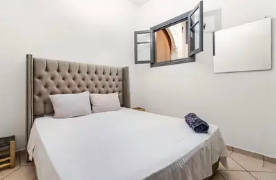 a bedroom with a large bed and a mirror at Stay here in Marrakech