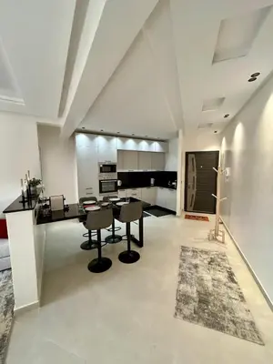 a kitchen with a table and chairs in a room at Appartement 2 chambres neuf Marjane Rte de Casa in Marrakech