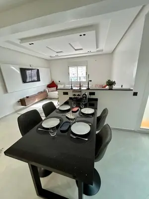 a black dining table and chairs in a living room at Appartement 2 chambres neuf Marjane Rte de Casa in Marrakech