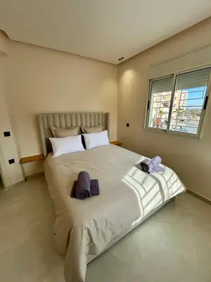 a bedroom with a large bed with towels on it at Appartement 2 chambres neuf Marjane Rte de Casa in Marrakech