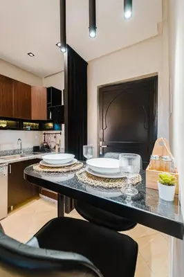a kitchen with a table with plates on it at Appartement Standing Marrakech Caricia in Marrakech