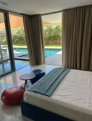 a bedroom with a bed and a swimming pool at Villa Brin d'Olive Marrakech 6 chambres in Gzoula