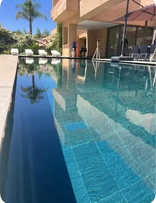 a swimming pool with blue water in a resort at Villa Brin d'Olive Marrakech 6 chambres in Gzoula