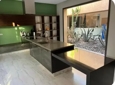 a kitchen with a black counter and some plants at Villa Brin d'Olive Marrakech 6 chambres in Gzoula
