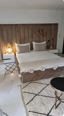a bedroom with a large bed with a wooden headboard at Villa Brin d'Olive Marrakech 6 chambres in Gzoula