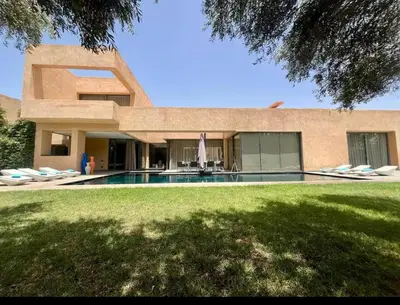 a house with a swimming pool next to a yard at Villa Brin d'Olive Marrakech 6 chambres in Gzoula