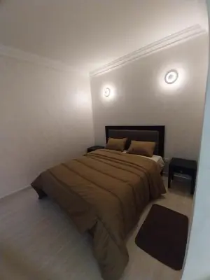 a bedroom with a large bed in a white room at Studio Elégant Gueliz in Marrakech