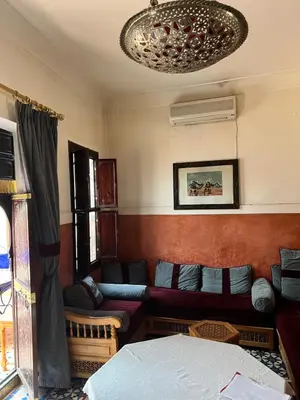 a living room with a couch and a chandelier at Riad Dar Aïlen Medina in Marrakech