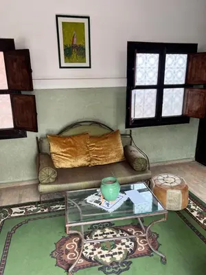 a living room with a couch and a glass table at Riad Dar Aïlen Medina in Marrakech