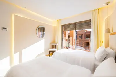 two beds in a room with a window at Appartment - Kasbel 2 - Pools & Spa & Gym Club in Marrakech