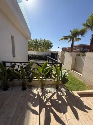 a bench in front of a building with palm trees at Villa Alfa Élégance, Calme & Confort Premium in Marrakech