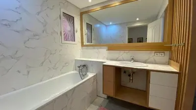 a bathroom with a sink and a tub and a mirror at Grand duplex Palmeraie in Marrakech