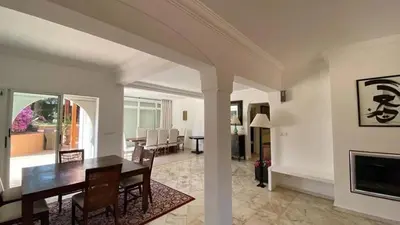 a dining room and living room with a table and chairs at Grand duplex Palmeraie in Marrakech
