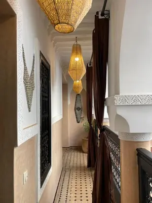 a hallway with a chandelier and a tiled floor at Riad Bloom in Marrakech