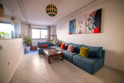 a living room with a blue couch with colorful pillows at La citrine A in Marrakech