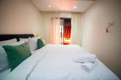 a bedroom with a large white bed with green pillows at La citrine A in Marrakech