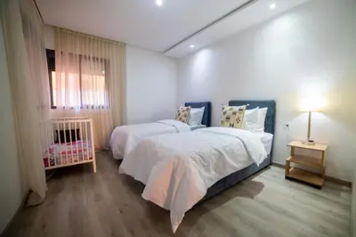 a bedroom with two beds and a crib in it at La citrine A in Marrakech