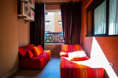a room with a couch and a chair and a window at La citrine A in Marrakech