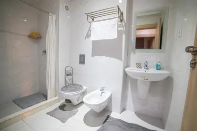 a white bathroom with a toilet and a sink at La citrine A in Marrakech