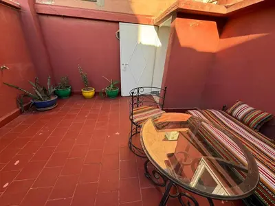 a patio with a table and chairs and potted plants at Riad Souleimane Résidence Qaria Siyahiya in Marrakech