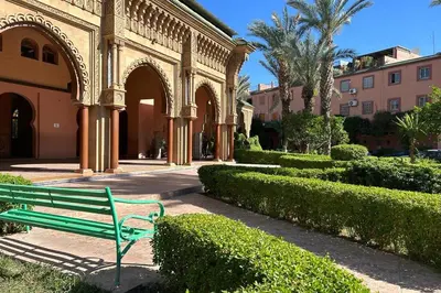 a green bench sitting in front of a building at Riad Souleimane Résidence Qaria Siyahiya in Marrakech