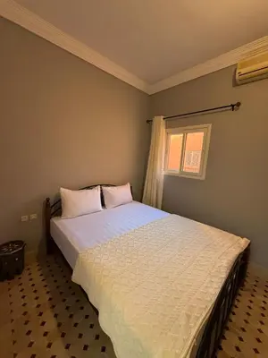 a bedroom with a large bed with white sheets and a window at Riad Souleimane Résidence Qaria Siyahiya in Marrakech