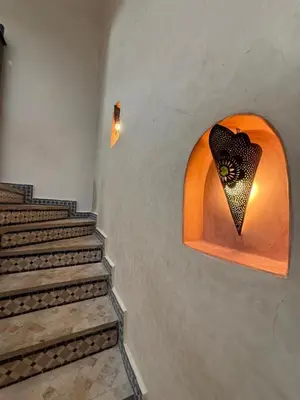 a set of stairs with a light on the wall at Riad Souleimane Résidence Qaria Siyahiya in Marrakech