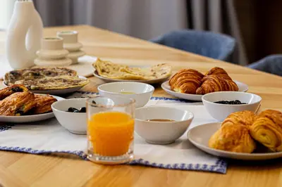 a table topped with plates of pastries and orange juice at Villa de prestige avec piscine privée in Marrakech