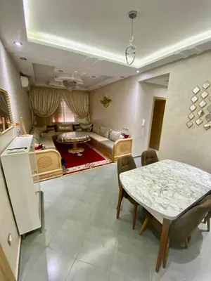 a living room with a table and a couch at Charmante moderne Wohnung in der Nähe des Flughafens in Marrakech