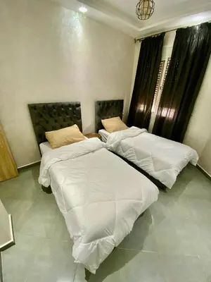 two beds in a hotel room with white sheets at Charmante moderne Wohnung in der Nähe des Flughafens in Marrakech