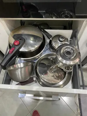 a shelf filled with pans and other kitchen utensils at Charmante moderne Wohnung in der Nähe des Flughafens in Marrakech