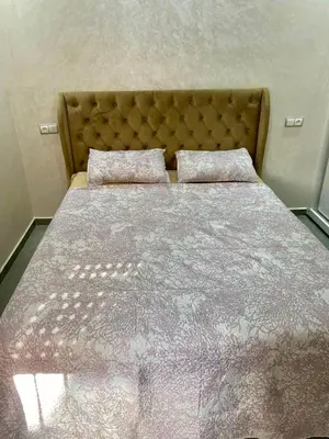 a bedroom with a large bed with a bedspread and pillows at Charmante moderne Wohnung in der Nähe des Flughafens in Marrakech