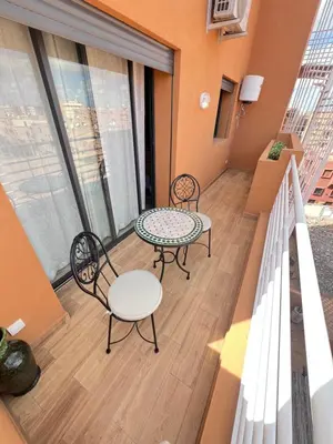 a balcony with two chairs and a table at dar nour alhuda in Marrakech