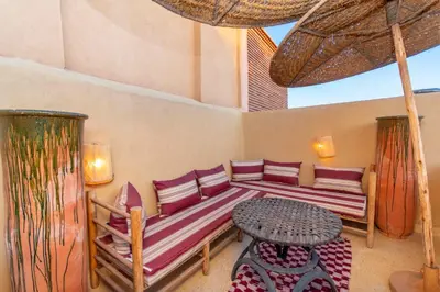 a room with a bed and a table and a umbrella at Riad Prive in Marrakech