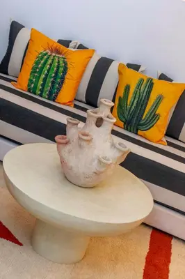 a vase sitting on a table in front of a couch at Riad Prive in Marrakech