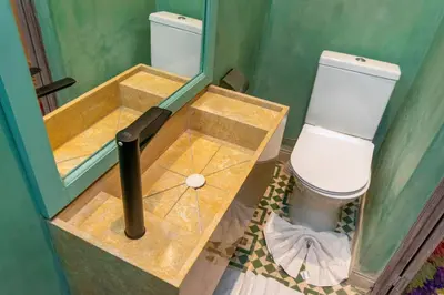 a bathroom with a toilet and a sink with a mirror at Riad Prive in Marrakech