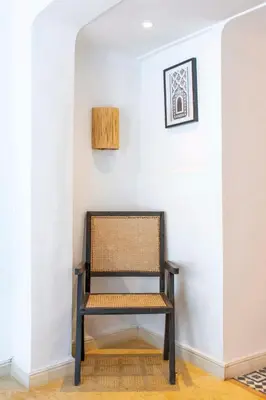 a chair in a room with a white wall at Riad Prive in Marrakech
