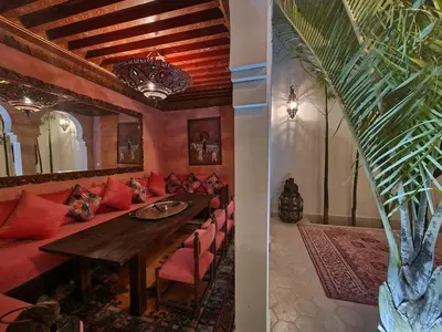 a living room with a red couch and a table at Riad Koubba in Marrakech