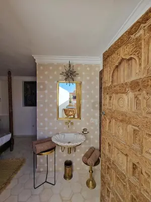 a bathroom with a sink and a large wooden door at Riad Koubba in Marrakech