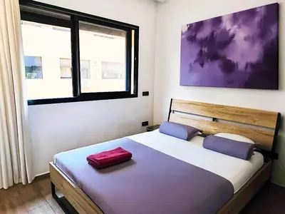 a bedroom with a large bed with a large window at Hypercenter Comfy apartment Marrakech pool in Marrakech